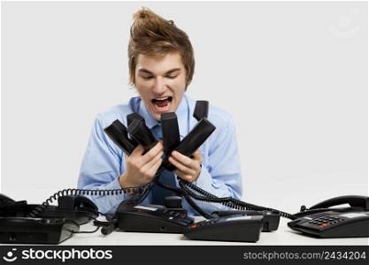 Young man holding and yelling to the phones