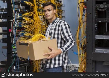 young man holding box with wires