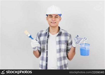 young man holding brush paint bucket
