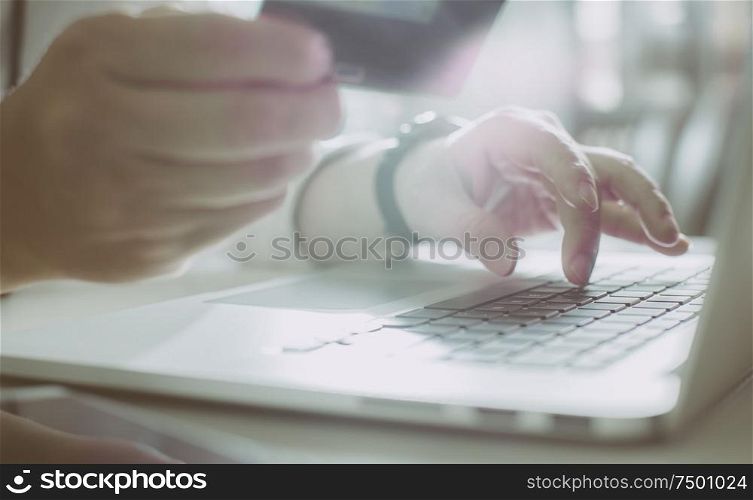 Young man holding credit card and using laptop computer. Online shopping concept,close up and selected focus .