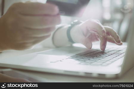 Young man holding credit card and using laptop computer. Online shopping concept,close up and selected focus .