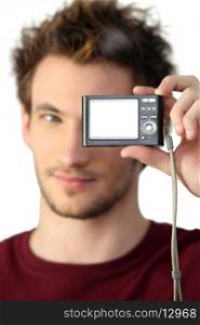 young man holding digital camera