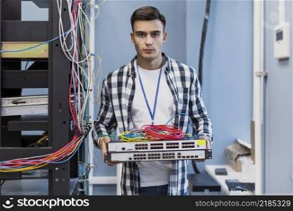 young man holding ethernet switches wires