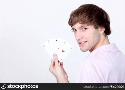 Young man holding four Aces