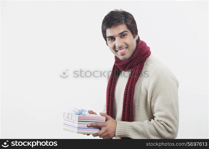 Young man holding gift box over white background