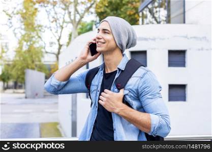 Young man holding mobile phone, using smartphone, making a call, talking on the phone