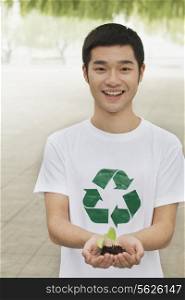 Young Man Holding Seedling in his Hands, Recycling Symbol, Beijing