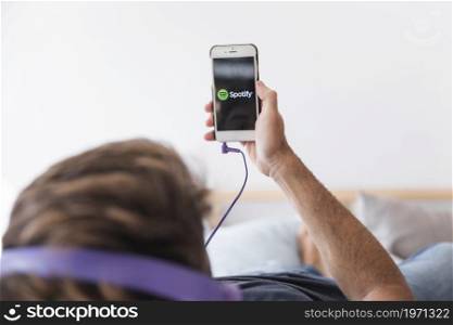 young man holding smartphone with spotify app. High resolution photo. young man holding smartphone with spotify app. High quality photo