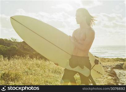 Young man holding surfboard