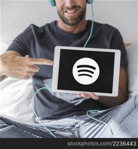 young man holding tablet with spotify app_2