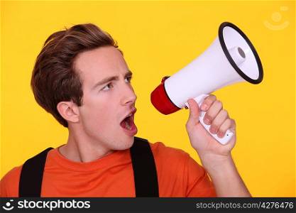 Young man hollering into a megaphone