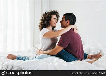 young man hugging happy woman bed