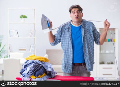 Young man husband doing clothing ironing at home