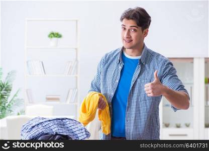 Young man husband doing clothing ironing at home