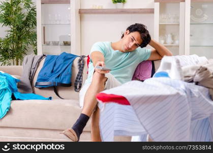 Young man husband ironing at home 