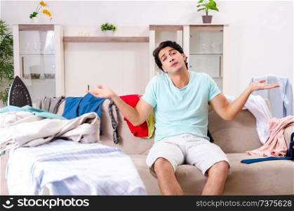 Young man husband ironing at home 