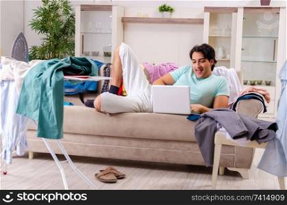 Young man husband ironing at home