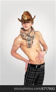 young man in a leopard print hat on tne white grey background, with a naked torso