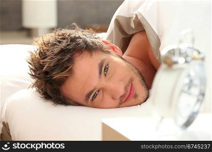 young man in bed waking up