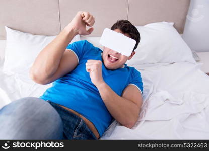 Young man in bed wearing a vr virtual reality head set