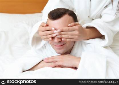 young man in bed with his eyes closed by woman