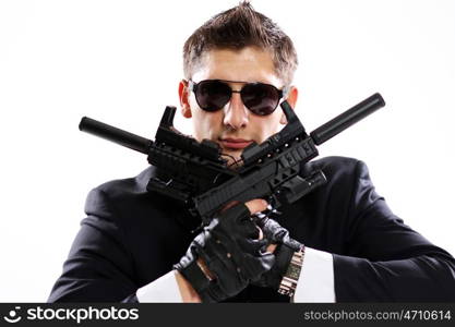 Young man in black suit holding gun isolated on white background