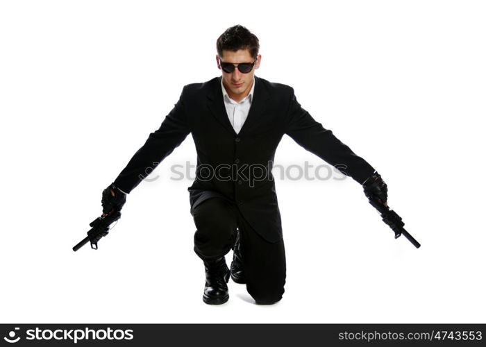 Young man in black suit holding gun isolated on white background