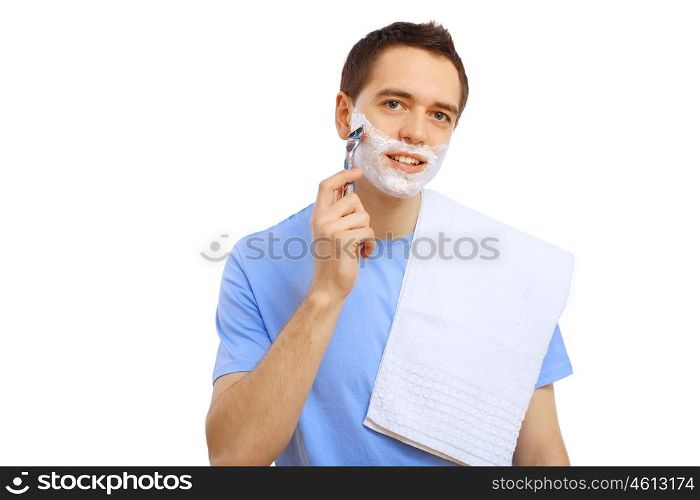 Young man in blue T-shirt shaving himself