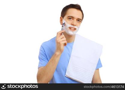 Young man in blue T-shirt shaving himself