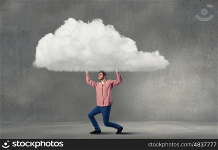 Young man in casual carrying cloud above head. Man lifting cloud