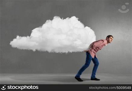 Young man in casual carrying cloud on back . Man lifting cloud