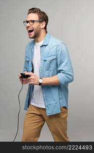 young man in casual jeans shirt holding joystick or gamepad playing game.. young man in casual jeans shirt holding joystick or gamepad playing game