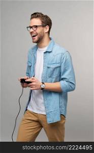 young man in casual jeans shirt holding joystick or gamepad playing game.. young man in casual jeans shirt holding joystick or gamepad playing game