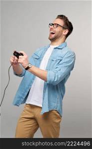 young man in casual jeans shirt holding joystick or gamepad playing game.. young man in casual jeans shirt holding joystick or gamepad playing game