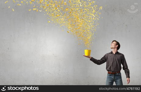Young man in casual splashing paint from bucket