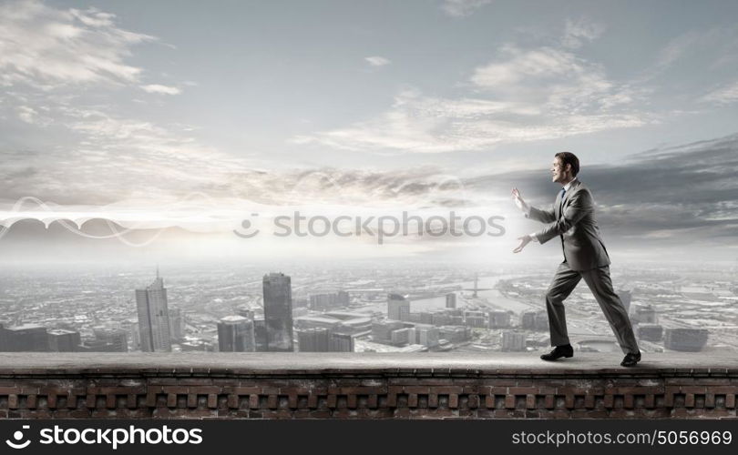 Young man in casual throwing magic light. Everything is under control