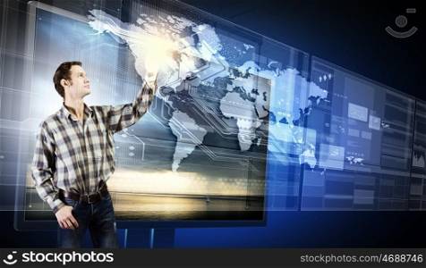 Young man in casual touching icon of media screen. Innovative technologies