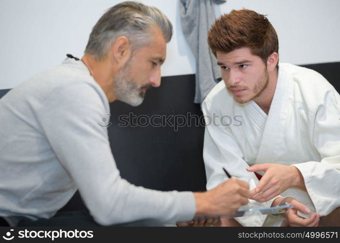 young man in kimono looking repectfully at older man