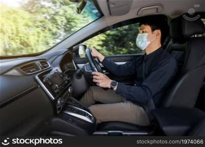young man in medical mask driving a car. for protect covid-19 (coronavirus) pandemic
