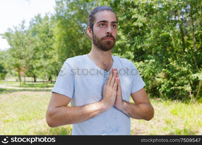 young man in meditation in forest