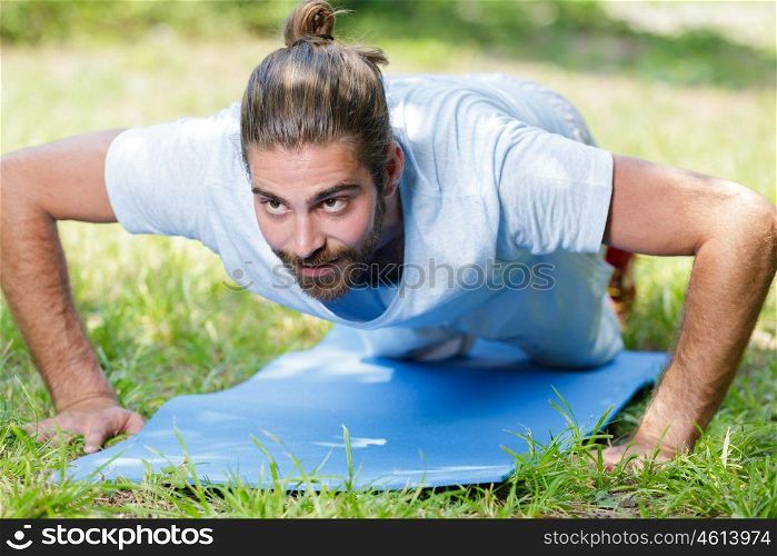 young man in plank position exercising outdoors