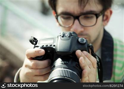 young man in spectacles with a camera