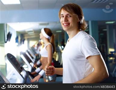 Young man in sport wear doing sport in gym