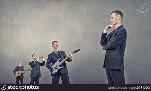 Young man in suit and people playing different music instruments. One man band
