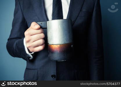 Young man in suit is holding a moka coffee pot