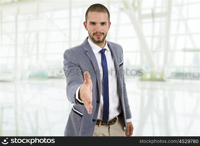 young man in suit offering to shake the hand at the office