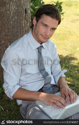 Young man in suit relaxing in a park