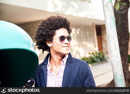 Young man in sunglasses by pay telephone