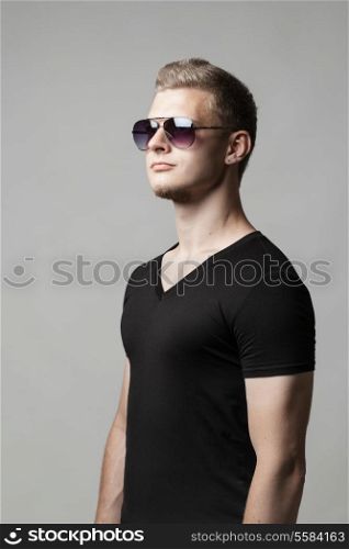 young man in sunglasses isolated on gray background