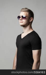 young man in sunglasses isolated on gray background